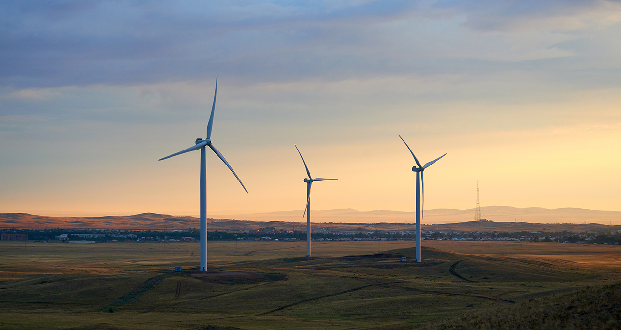 wide shot of wind turbines during sunset