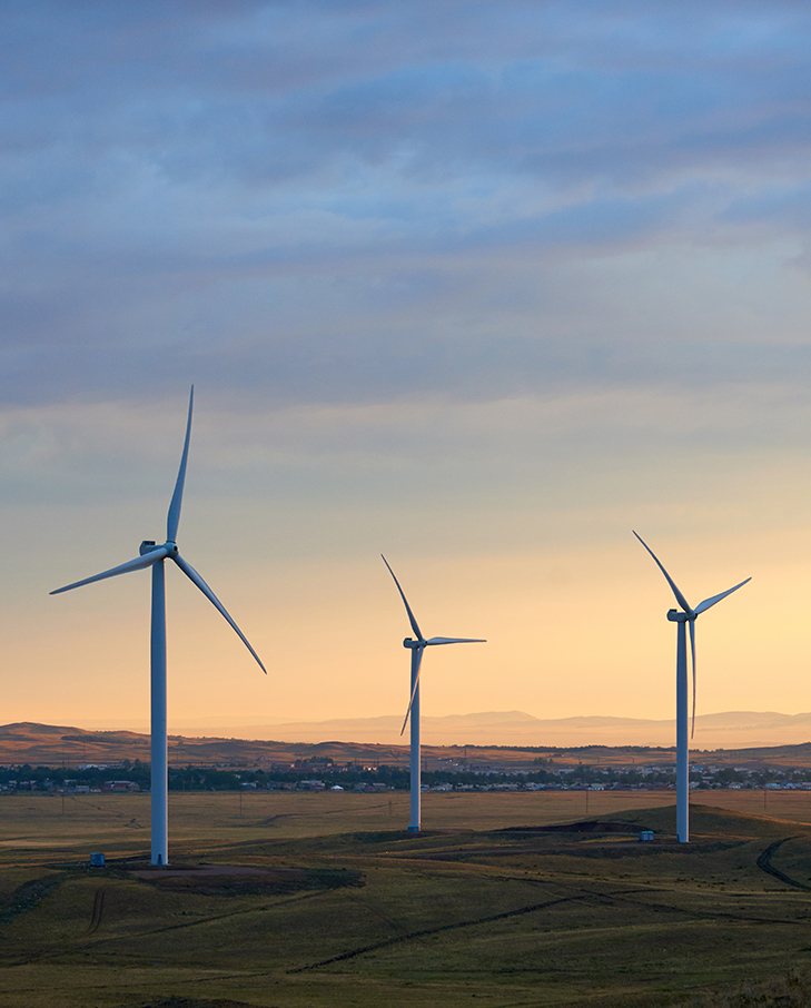 wide shot of wind turbines during sunset