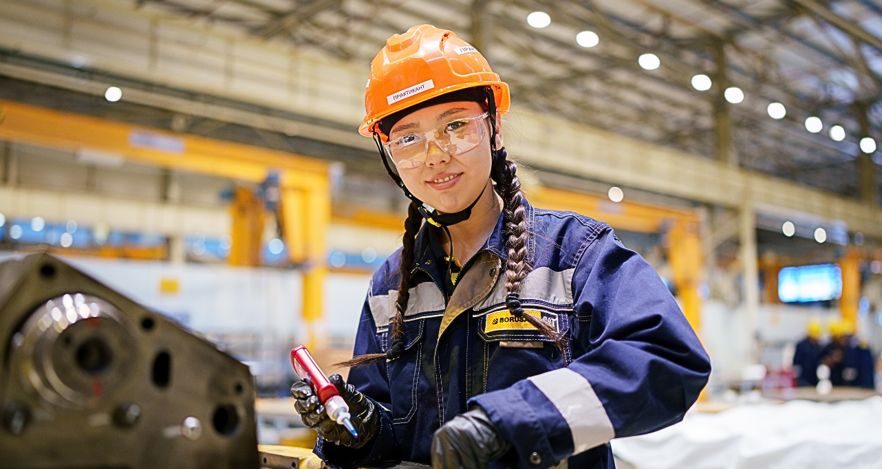 Woman working in factory, inspecting machinery