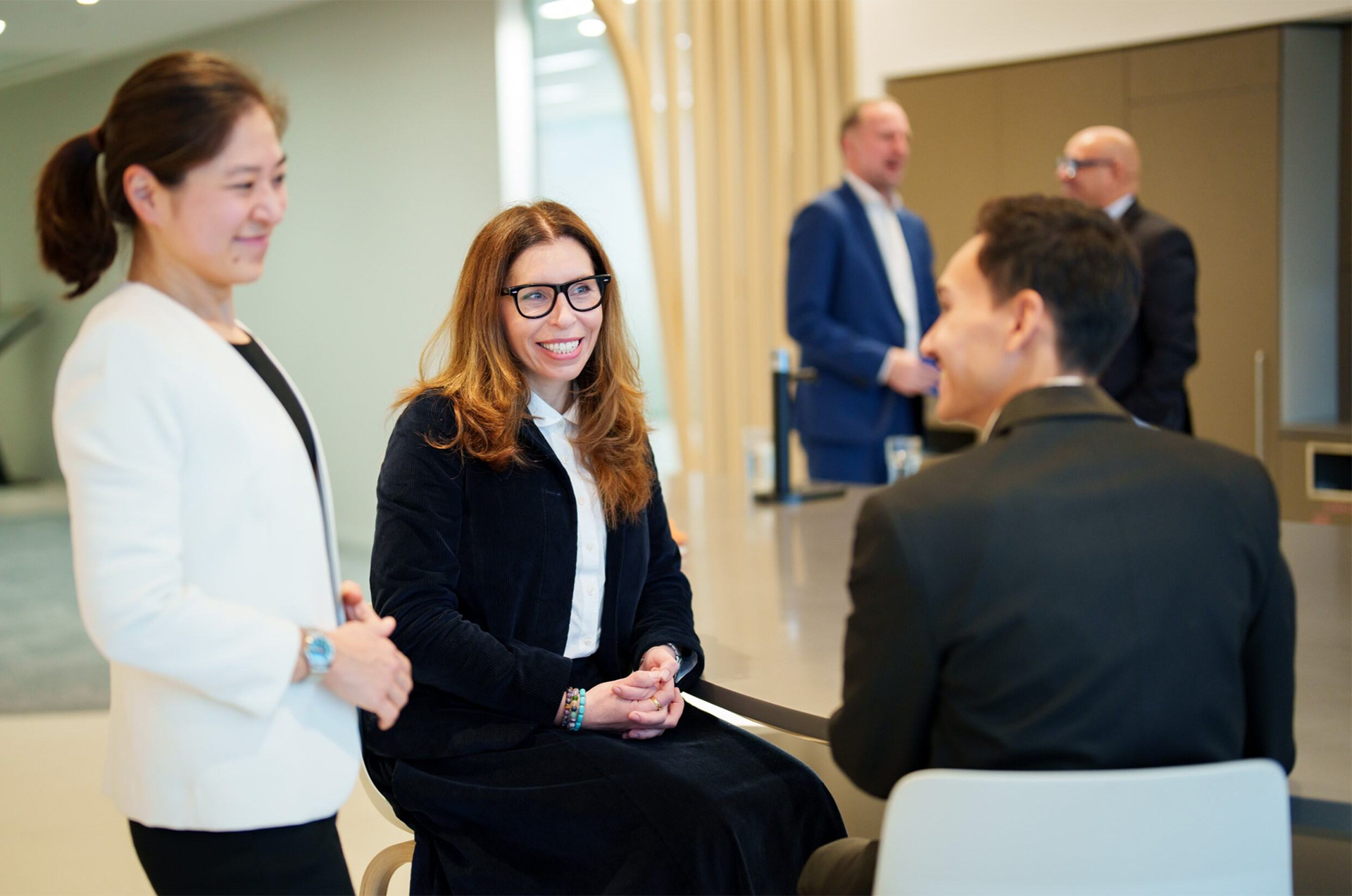 people in discussion at a table in a corporate office location