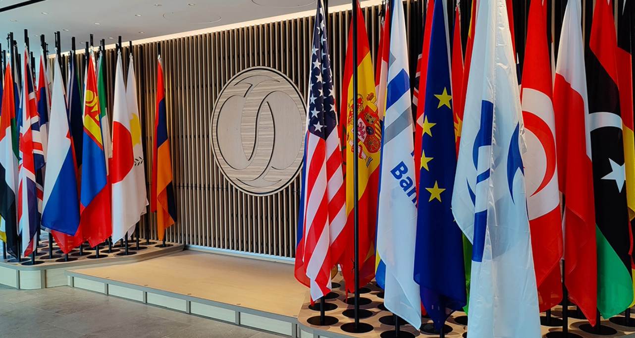 Numerous international flags next to a podium on stage